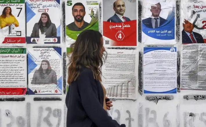 Posters in Tunis for candidates running in the Tunisian national election on Saturday 17 December. Photograph: Fethi Belaid/AFP/Getty Images