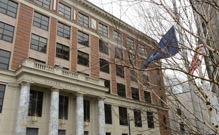 The Alaska and national flags fly at half-mast on Tuesday, April 6, 2021 in front of the Alaska State Capitol in Juneau. (James Brooks / ADN)