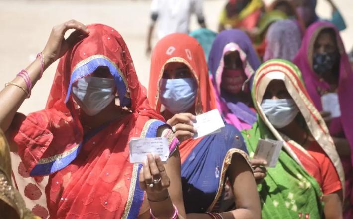 Women show voter ID cards during Panchayat election, at Bakkas polling centre on April 19, 2021 in Lucknow, India. Deepak Gupta/Hindustan Times via Getty Images / Time 