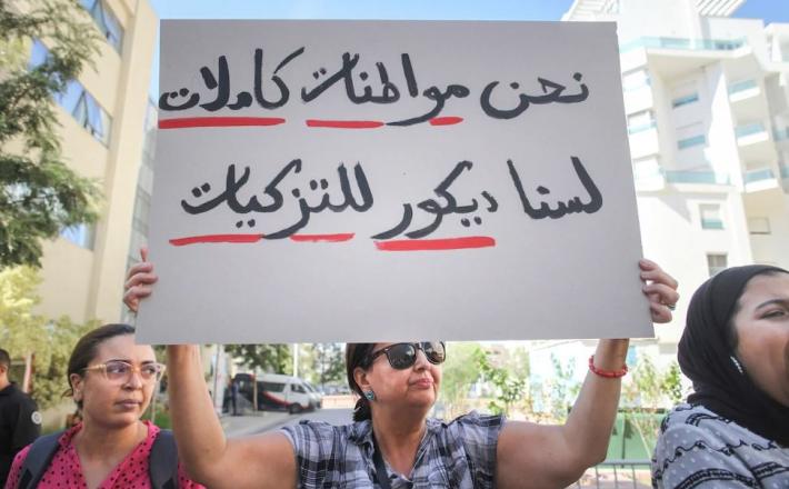 A Tunisian woman holds up a placard that reads in Arabic: “We are full citizens, not a decoration for sponsorships,” during a demonstration in Tunis, Tunisia on October 7, 2022. © 2022 Chedly Ben Ibrahim/AP Photo